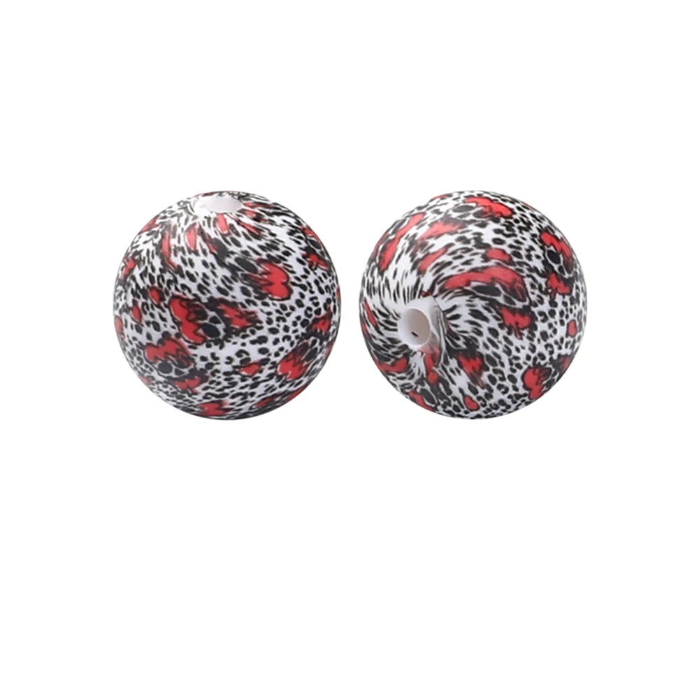 Pair of spherical silicone beads with a leopard print and red floral pattern for jewelry making