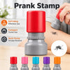 A set of colorful self-inking prank stamps in various colors displayed on a wooden surface.