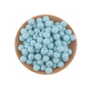A wooden bowl filled with numerous light blue silicone round beads for jewelry making and crafts.