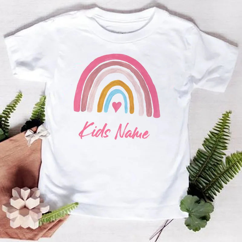 White t-shirt featuring a pink and yellow rainbow design with the text Kids Name printed on the chest.