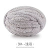 A ball of light gray chunky chenille yarn used for hand knitting projects.
