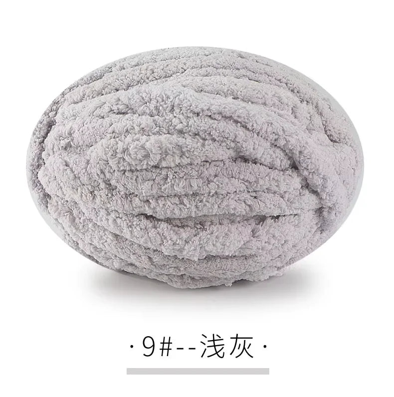A ball of light gray chunky chenille yarn used for hand knitting projects.