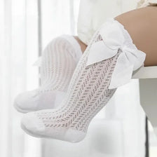 White lace knee socks for a baby girl with a decorative bow