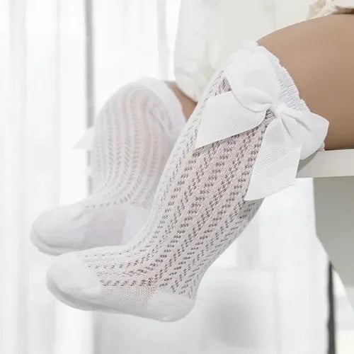White lace knee socks for a baby girl with a decorative bow