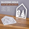 A white silicone mold set for house, love, and Christmas ornaments is displayed on a wooden surface.