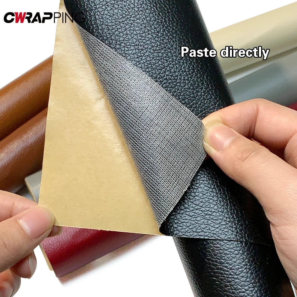 A hand is applying a black PU leather self-adhesive repair patch onto a dark leather surface.