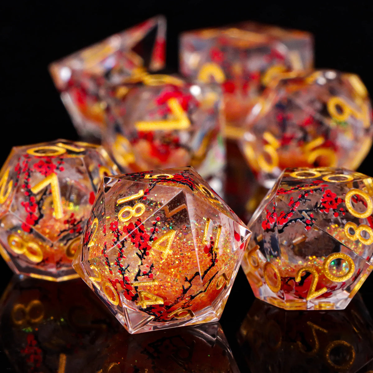 A close-up of a set of translucent resin dice with an orange and red galaxy pattern, reflecting on a dark surface.