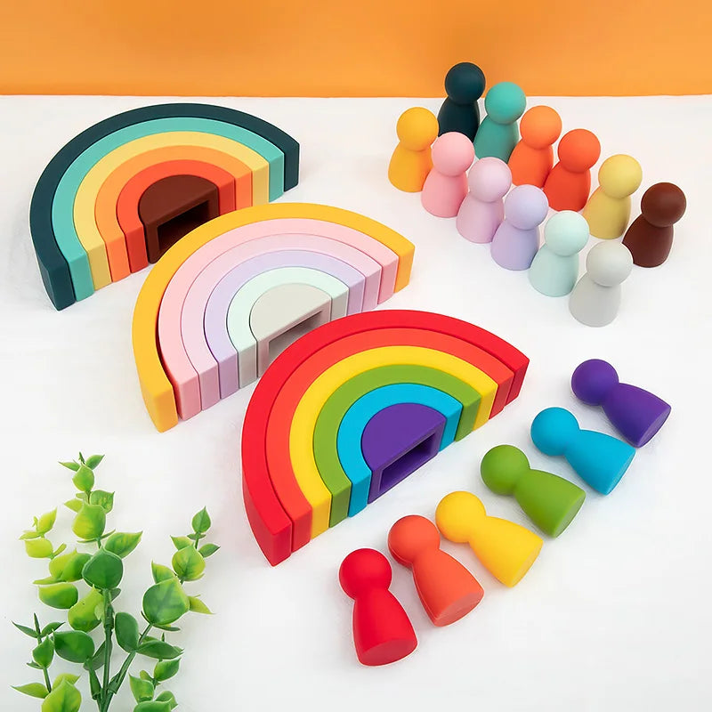 A set of soft silicone rainbow building blocks in various colors arranged in a rainbow arc.