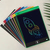 A stack of colorful, reusable LCD drawing tablets for kids, featuring a rocket design on the top tablet.