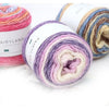 Spools of gradient rainbow yarn in various shades and textures for knitting and crochet projects