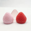 Three squishy fidget toys shaped like strawberries in pink, clear, and red colors