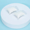 A white mini sofa and pillow set for a dollhouse displayed on a light blue background.