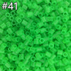 A pile of 1000 assorted green fuse beads for creative craft projects.