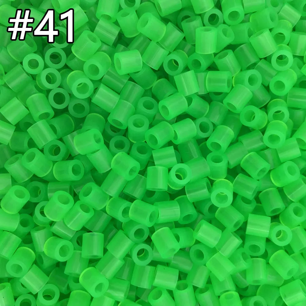 A pile of 1000 assorted green fuse beads for creative craft projects.
