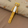 A yellow and white stuffed bear plushie lying on a beige fabric surface.