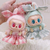 A pair of cute plush dolls dressed in pink and green plaid outfits with bunny ears