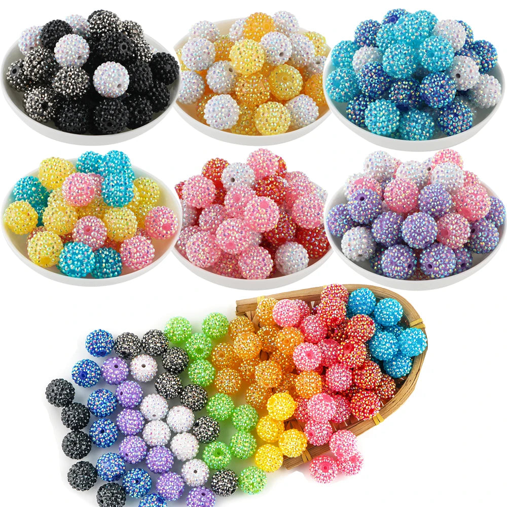 A collection of colorful rhinestone acrylic beads in various shades including black, yellow, pink, blue, and purple.