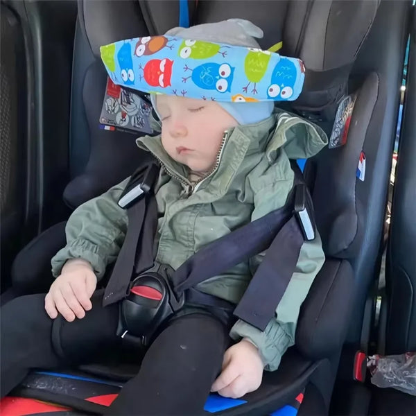 A baby is seated in an adjustable car seat with a colorful head rest and safety harness.