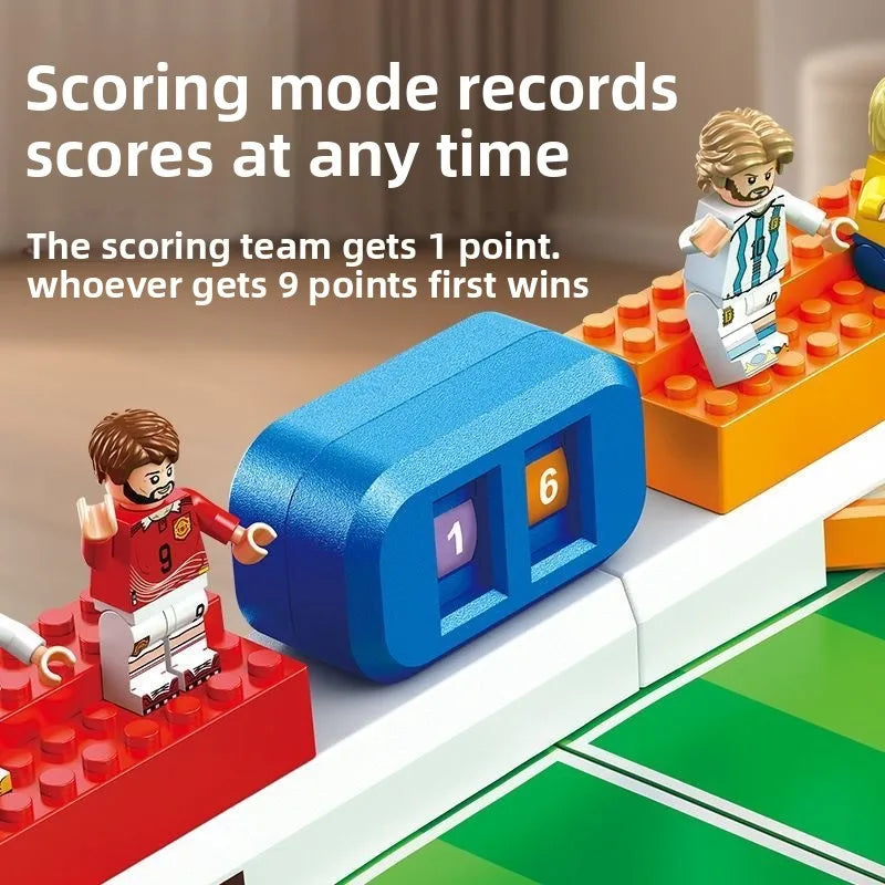 A close-up of a mini tabletop foosball game setup showing players and scoring mechanism on a green playing surface.