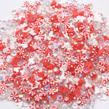 A pile of small, translucent polymer clay slices in red and white patterns for slime and craft projects.