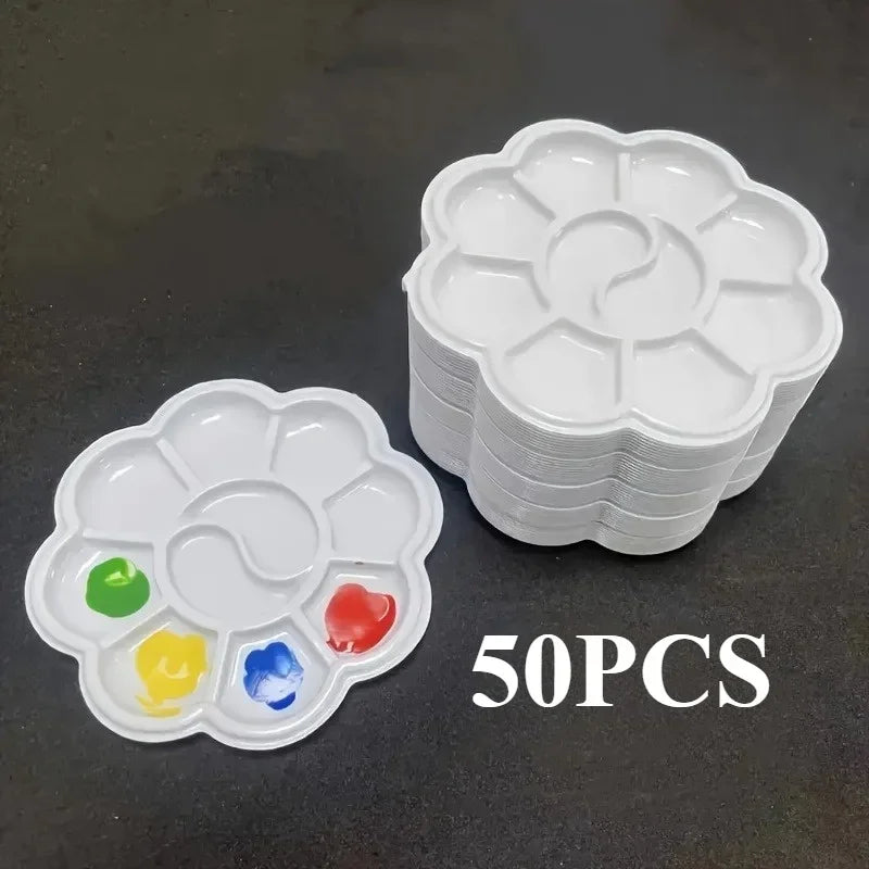 A stack of white flower-shaped disposable paint palettes with colored paint samples on the bottom