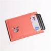 A pink card holder wallet featuring a cat superhero design and holding multiple cards.