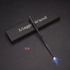 A black magic wand with a glowing blue tip rests on a dark surface.