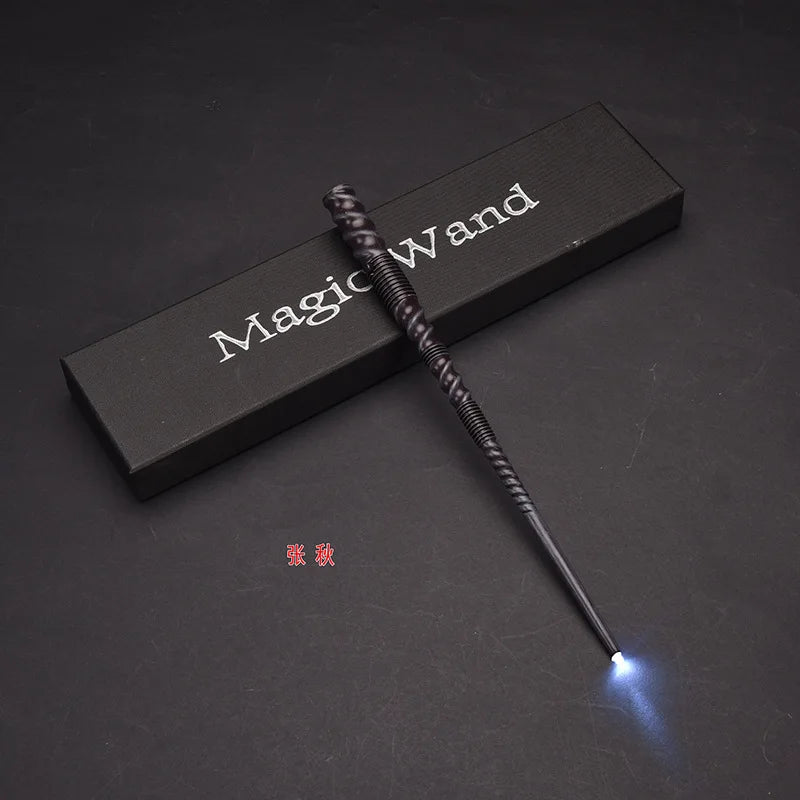 A black magic wand with a glowing blue tip rests on a dark surface.