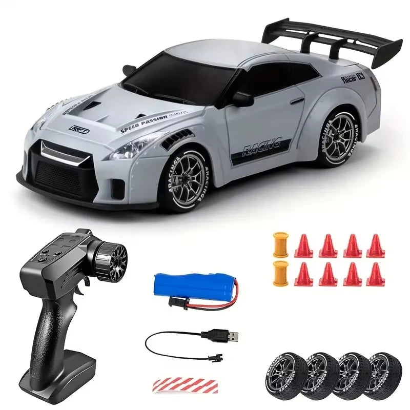 A silver 4WD RC drift car with black accents and LED lights, shown next to its accessories.