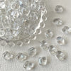 A pile of clear geometric glass beads in irregular square shapes for jewelry making