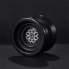 A close-up view of a black metal yo-yo with a star-shaped design.