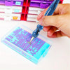 A hand holds a blue diamond art pen with an interchangeable tip, poised over a clear plastic box containing a grid of small p