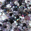 A close-up view of a variety of colorful acrylic bow beads and small glass beads in various shades and shapes.