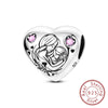 A sterling silver heart charm bead featuring a detailed design of two embracing figures and pink accent stones.
