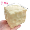 A light yellow, squishy stress ball with a porous texture is held in a hand.