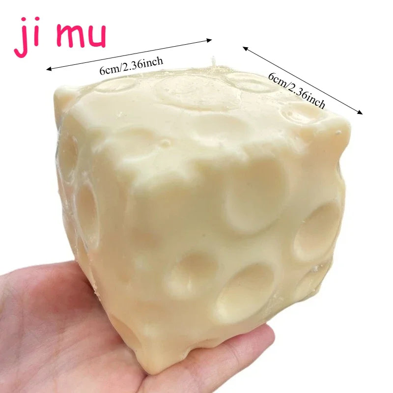 A light yellow, squishy stress ball with a porous texture is held in a hand.