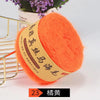 A ball of bright orange mohair blended yarn is displayed next to a gold wire rack.