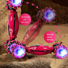 A pink 4WD RC stunt car with LED lights is shown performing stunts on sand, demonstrating air gesture and remote control feat