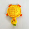 Handmade crochet lizard coaster in bright yellow with orange accents and a green tip