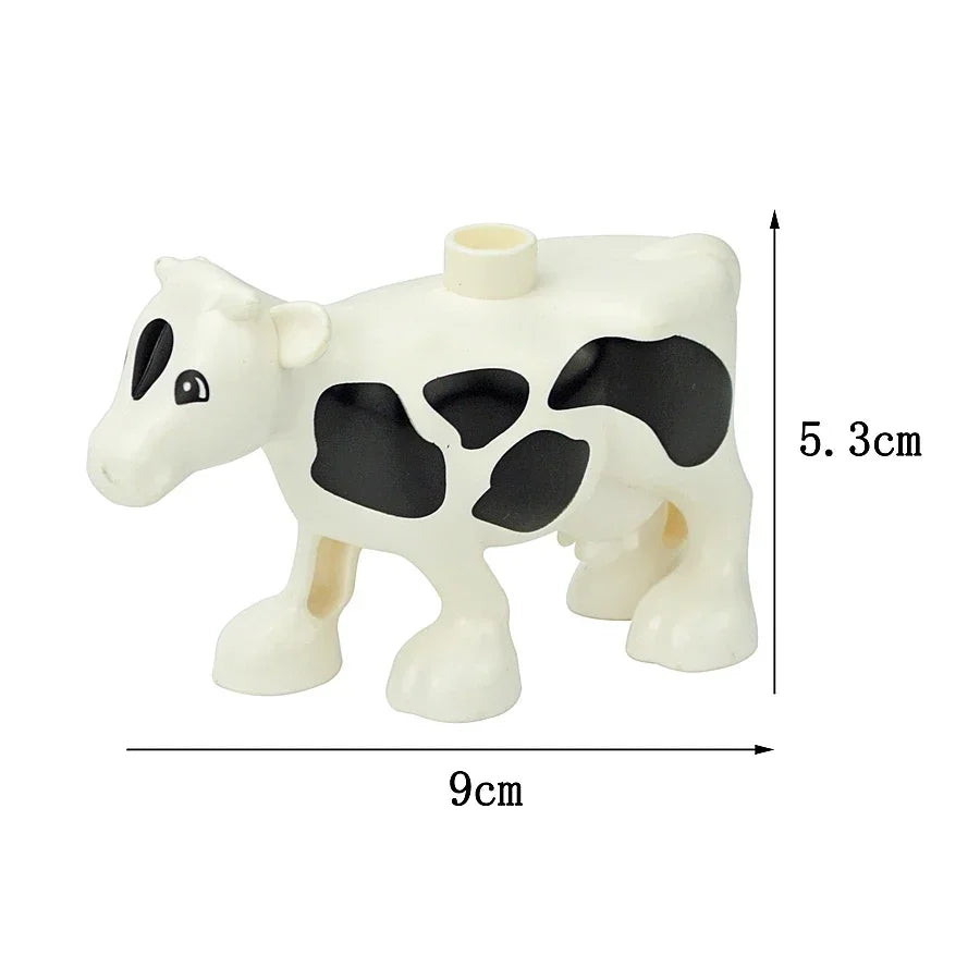 A white and black cow shaped building block with a cylindrical head, measuring 5.3 cm high and 9 cm long.