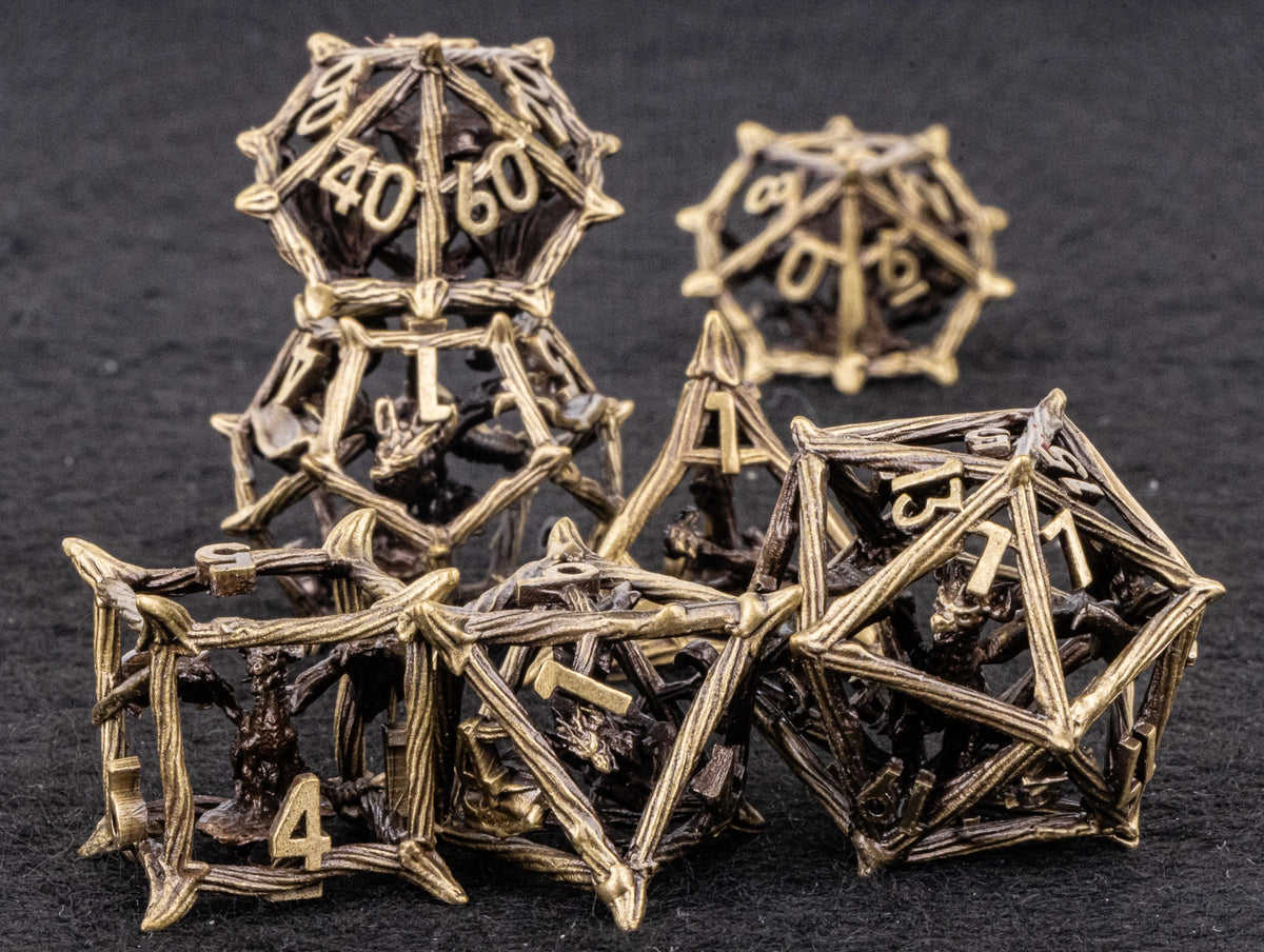 A set of metal dice shaped like dragons, used for D&D and tabletop RPGs.
