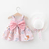 A pink floral baby girl summer dress and sunhat set with bow details displayed on a hanger.