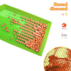 A green tray holds numerous round, colored beads used for a diamond painting kit.