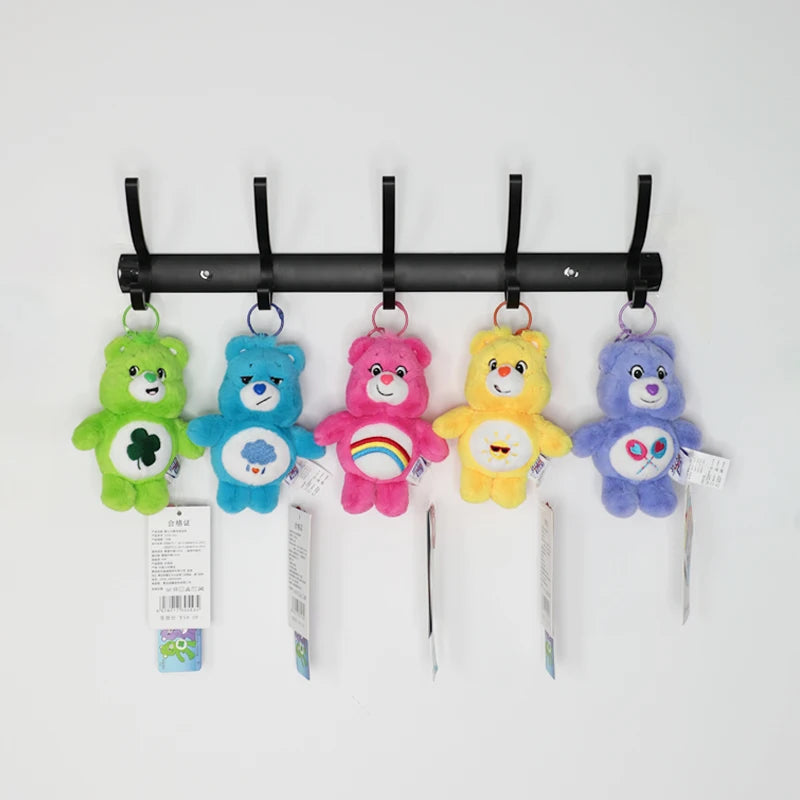 A collection of colorful Care Bears plush keychains hanging from a black rack.
