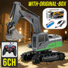 A gray and green 1:24 scale remote control excavator with an original box and a controller shown on sand.
