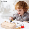 A young child is interacting with a wooden lock and key toy set, demonstrating unlocking skills.