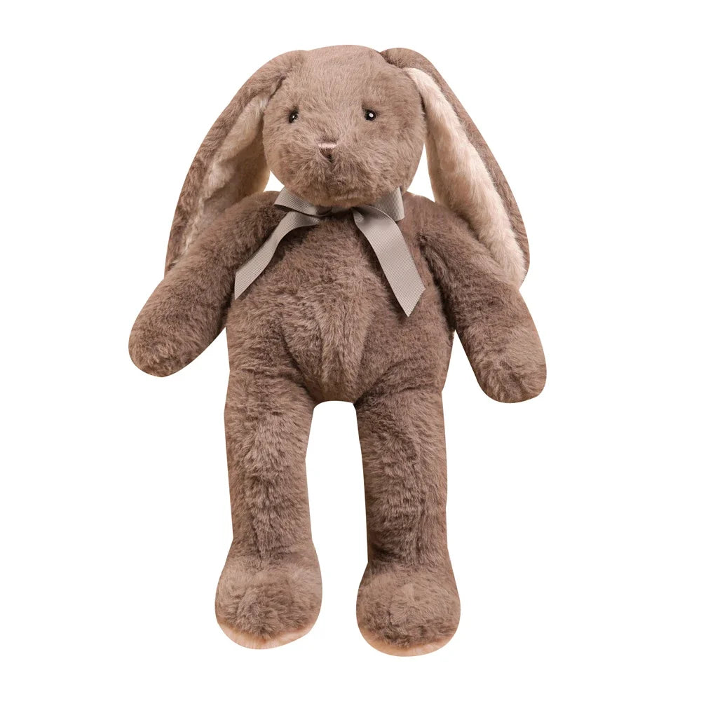A soft brown bunny plush toy with long floppy ears tied with a ribbon.