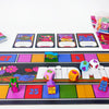 A board game setup showing colorful racing tiles, plastic tokens, and game components for a magical athlete theme.