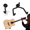 A black metal guitar wall mount hanger is shown next to an acoustic guitar.