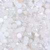 A close-up view of a mix of clear and milky white glass beads for DIY jewelry making